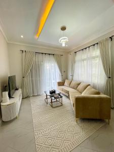 sala de estar amplia con sofá y TV en Mayvad Homes, en Kampala