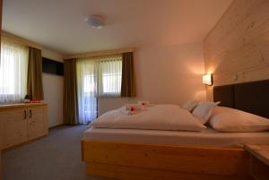 a bedroom with a large white bed with two pink roses at PRIVILLAGE Stare - B&B in Bohinj
