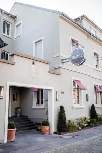 ein weißes Gebäude mit Schild für ein Hotel in der Unterkunft Romantikhotel Rebstock art & design in Kehl am Rhein