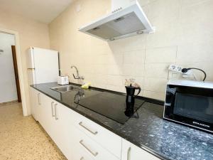 a kitchen with a sink and a microwave at Apartment Escor 3000 in Segur de Calafell