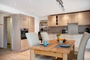 a kitchen with a wooden table and white chairs at Ferienwohnung Birke in Altusried