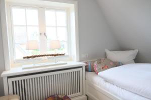 a small bedroom with a bed and a window at Osterweg-53c-DHH in Wenningstedt
