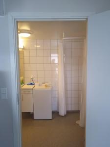 een badkamer met een wastafel en een witte tegelmuur bij The Haus in Moss