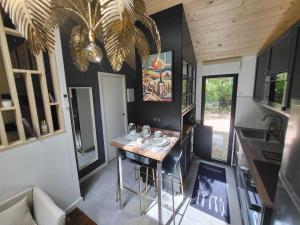 a small kitchen with a table in a tiny house at L'Ecrin sous les Chênes in Gradignan