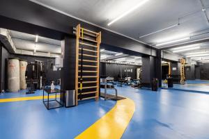a room with a gym with blue flooring and a gym at Solo Society Kaunas Apartments in Kaunas