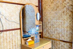 a dressing table with a mirror on a wall at Ruenpakkiangnan เรือนพักเคียงน่าน in Phitsanulok