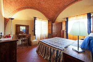 a bedroom with a bed and a table in a room at Fonte Del Castagno in Sinalunga