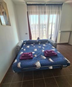 a bed in a room with a blue comforter at Milano Santa Giulia Business Apartment - Olimpiadi 26 in Milan