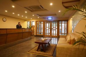 a man standing at a bar in a living room at Falettis Express DHA in Lahore