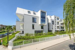 an apartment building with a white facade at Lion Apartments - Sopot Fresh Wave Apartment with terrace and parking in Sopot
