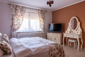a bedroom with a bed and a tv and a mirror at Vila Crisalia Sibiel -Sibiu in Sibiel