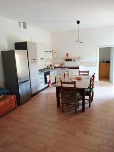 La cuisine est équipée d'une table, de chaises et d'un réfrigérateur. dans l'établissement House Edda Serena - Casa Vacanze Salerno, à Pontecagnano