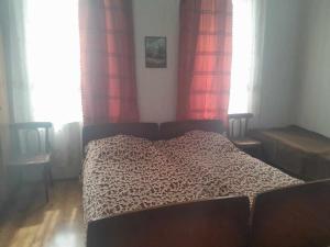 Ce lit se trouve dans une chambre dotée de rideaux rouges et d'un lit sidx sidx. dans l'établissement Holiday Home Ekaterine, à Telavi