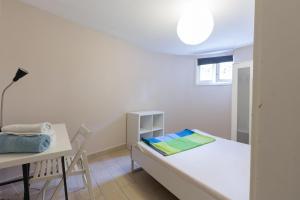 Cette chambre blanche dispose d'une table, d'un lit et d'un bureau. dans l'établissement Relógio Guest House, à Porto