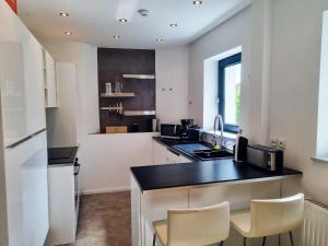 a kitchen with a black counter top and a sink at maremar - City Design Apartment - Luxus Boxspringbetten - Highspeed WIFI - Arbeitsplätze in Braunschweig