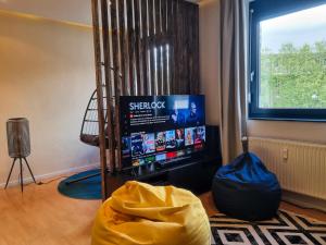 un soggiorno con TV a schermo piatto in una camera di maremar - City Design Apartment - Luxus Boxspringbetten - Highspeed WIFI - Arbeitsplätze a Braunschweig