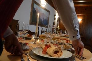 a person standing at a table with a plate of food at Hotel Margherita in San Martino di Castrozza