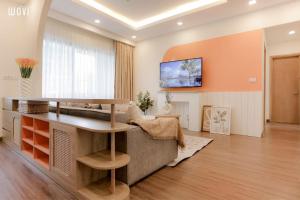 a living room with a couch and a tv on the wall at FLC Sea Tower Wins Quy Nhơn in Quy Nhon