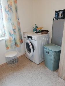een wasmachine en een stoel in de kamer bij Gartenland Gela in Kitzingen