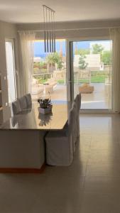 Villa Almaza 5 bedrooms في مرسى مطروح: غرفة طعام مع طاولة وكراسي وإطلالة على المحيط