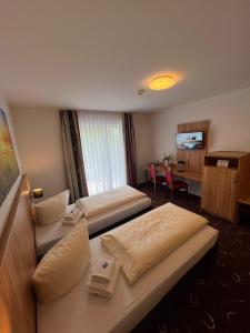 a hotel room with two beds and a couch at Schäfer Boardinghouse in Gröbenzell