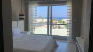 Villa Almaza 5 bedrooms في مرسى مطروح: غرفة نوم بسرير ونافذة كبيرة
