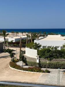 Villa Almaza 5 bedrooms في مرسى مطروح: اطلالة على شاطئ به مبنى واشجار