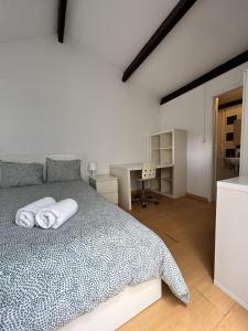 um quarto com uma cama com lençóis brancos e uma secretária em Relógio Guest House no Porto