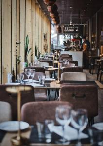 a restaurant with wooden tables and chairs with wine glasses at Hotel Birger Jarl in Stockholm