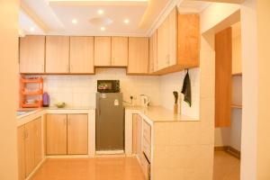 a kitchen with wooden cabinets and a black refrigerator at Effie Homes in Naivasha