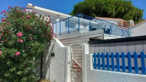 une maison blanche avec un balcon bleu et un arbre dans l'établissement La colombe, à Argelès-sur-Mer