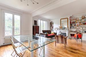 a living room with a glass table and chairs at Résidor - Appartement 4P chaleureux et lumineux ! in Paris