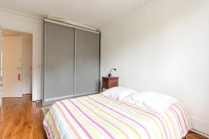 1 dormitorio con 1 cama y armario grande en Résidor - Appartement 4P chaleureux et lumineux !, en París