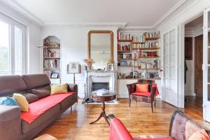 sala de estar con sofá y chimenea en Résidor - Appartement 4P chaleureux et lumineux !, en París