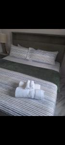 a bed with two towels and two pillows on it at Shauna apartment in Charlton