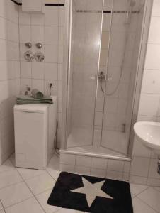 baño con ducha, aseo y alfombra de estrella en Fewo 4 en Gotha
