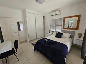 a bedroom with a bed and a desk in it at Li-Bru Self Catering Accommodation in Windhoek