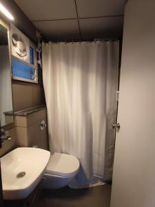 La salle de bains est pourvue de toilettes blanches et d'un lavabo. dans l'établissement Alpha Room, à Ahmedabad