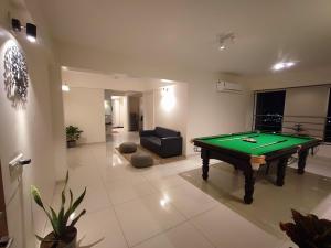 a living room with a pool table and a couch at Alpha Room in Ahmedabad
