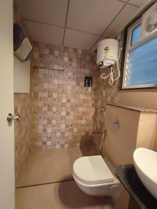 La petite salle de bains est pourvue de toilettes et d'un lavabo. dans l'établissement Alpha Room, à Ahmedabad