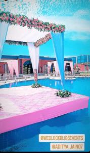a pavilion with flowers on top of a swimming pool at Tropical Palms in Gurgaon