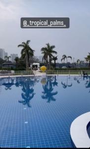 a large swimming pool in a resort with palm trees at Tropical Palms in Gurgaon