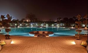 a large swimming pool at night with lights at Tropical Palms in Gurgaon