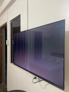 a large flat screen tv hanging on a wall at Maria kulafu studio 2 in Masbate