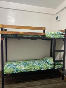 two bunk beds in a room with a bed at Maria kulafu studio 2 in Masbate