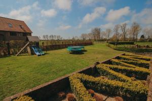un jardín con una mesa de picnic y un parque infantil en Authentieke Boerderij Woning, en Retranchement