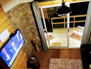 una vista aérea de una sala de estar con TV y un porche en Hermosa cabaña con excelente vista panorámica en Piriápolis
