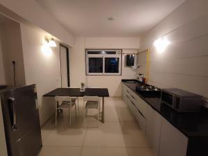 uma pequena cozinha com uma mesa e um frigorífico em Beta Room em Ahmedabad