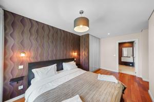 um quarto com uma cama grande e uma cabeceira em madeira em Bessa Luxury Flat by Amber Star Rent no Porto