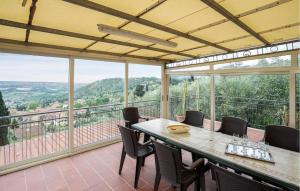 a dining room with a table and chairs on a balcony at Gorgeous Apartment In Corsanico With House A Panoramic View in Corsanico-Bargecchia